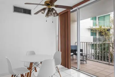 a ceiling fan in a living room with a balcony at Bay Harbor Sunset Apt 2B in Miami Beach
