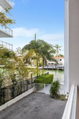 a balcony with a view of the water and palm trees at Bay Harbor Sunset Apt 2B in Miami Beach
