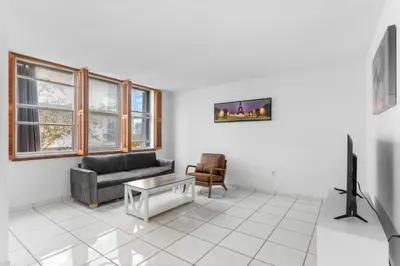 a living room with a couch and a tv at Bay Harbor Sunset Apt 2B in Miami Beach