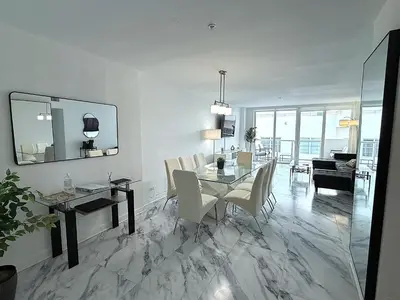 a dining room and living room with a table and chairs at Oceanfront Luxury Miami Escape Pool&Gym in Miami Beach