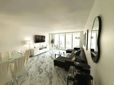 a living room with a couch and a mirror at Oceanfront Luxury Miami Escape Pool&Gym in Miami Beach