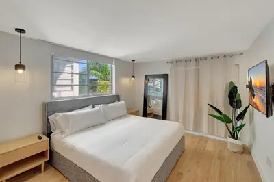 a bedroom with a large white bed and a window at Modern 2Bedroom in South Beach - Steps away from Lincoln Rd in Miami Beach