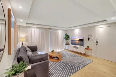 a living room with a couch and a tv at Modern 2Bedroom in South Beach - Steps away from Lincoln Rd in Miami Beach