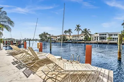 a group of chairs sitting on a dock in the water at Bay Harbor Sunset Apt 3B in Miami Beach