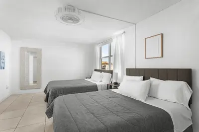 a hotel room with two beds and a window at Bay Harbor Sunset Apt 4A in Miami Beach