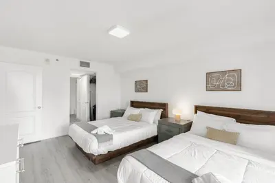 two beds in a bedroom with white walls at Stylish Brickell Condo with Stunning Views & Premier Amenities in Miami