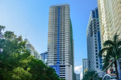 a tall apartment building with blue stairs in a city at Stylish Brickell Condo with Stunning Views & Premier Amenities in Miami