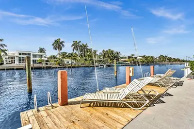 a group of chairs sitting on a dock next to the water at Bay Harbor Sunset Apt 4B in Miami Beach