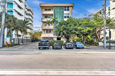a group of cars parked in a parking lot in front of a building at Bay Harbor Sunset Apt 4B in Miami Beach