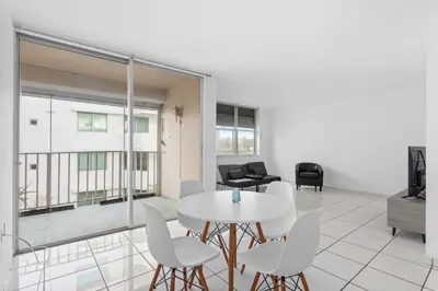 a living room with a white table and chairs at Bay Harbor Sunset Apt 4B in Miami Beach