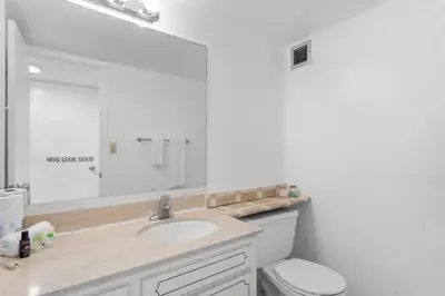 a white bathroom with a sink and a toilet at Bay Harbor Sunset Apt 4B in Miami Beach