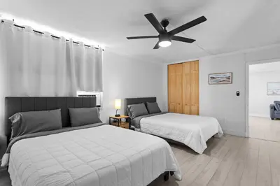 a bedroom with two beds and a ceiling fan at Bay Harbor Sunset Apt 5A in Miami Beach