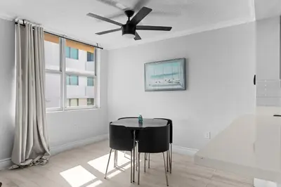 a dining room with a ceiling fan and a table at Bay Harbor Sunset Apt 5A in Miami Beach
