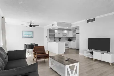 a living room with a couch and a flat screen tv at Bay Harbor Sunset Apt 5A in Miami Beach
