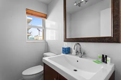 a bathroom with a sink and a toilet and a mirror at Bay Harbor Sunset Apt 5A in Miami Beach
