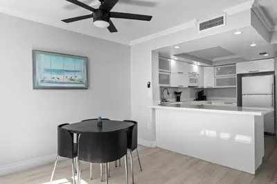 a kitchen with a black table and black chairs at Bay Harbor Sunset Apt 5A in Miami Beach