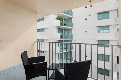 a balcony with two chairs and a building at Bay Harbor Sunset Apt 5B in Miami Beach