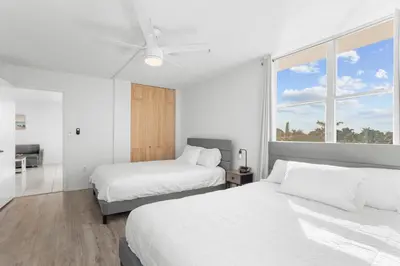 a bedroom with two beds and a ceiling fan at Bay Harbor Sunset Apt 5C in Miami Beach