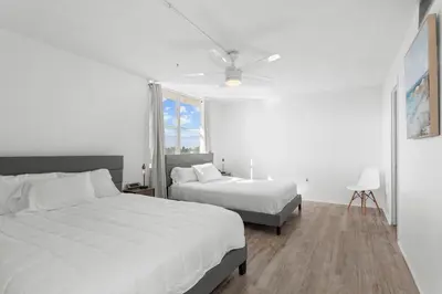 a bedroom with two beds and a ceiling fan at Bay Harbor Sunset Apt 5C in Miami Beach