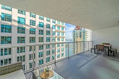 a balcony with a table and chairs on a building at Waterfront and City Lights 1-BR With Free Parking in Miami