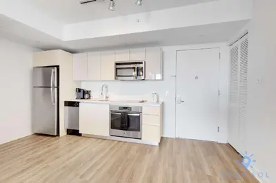 a kitchen with white cabinets and stainless steel appliances at Stylish Apartment Pool & Balcony in Hallandale Beach