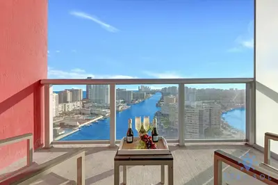 a view of a river from a balcony with wine bottles at Stylish Apartment Pool & Balcony in Hallandale Beach