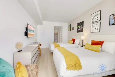 a bedroom with two beds and a tv at Apartment with Ocean View Balcony in Hollywood