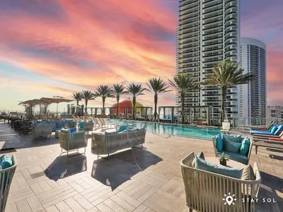 a resort with a pool and palm trees and a building at Apartment with Ocean View Balcony in Hollywood
