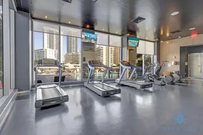 a gym with several cardio equipment in a building at Modern Apartment 2BR- Balcony Pool Gym in Hallandale Beach