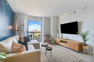 a living room with a couch and a tv at Modern Apartment 2BR- Balcony Pool Gym in Hallandale Beach