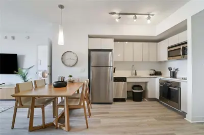 a kitchen with a wooden table and a dining room at Modern Apartment 2BR- Balcony Pool Gym in Hallandale Beach