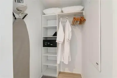 a white closet with white towels on racks at Spectacular Apartment with Balcony & Pool in Hallandale Beach
