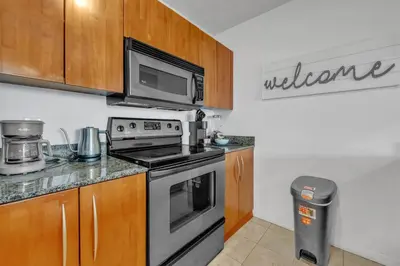 a kitchen with a stove and a microwave at Cozy 1 Bedroom Apt in The Heart of Brickell in Miami