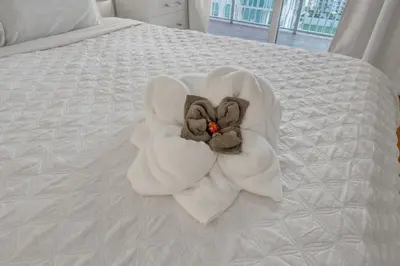 a white towel with a flower on a bed at Cozy 1 Bedroom Apt in The Heart of Brickell in Miami