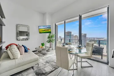 a living room with a white couch and a glass table at City Views Studio Downtown Miami in Miami
