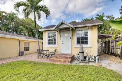 a small yellow house with a table and chairs at Shared Pool and Backyard Small and Cozy Guest House in Fort Lauderdale