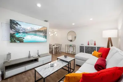 a living room with a white couch and a tv at Turtle Nest Bungalow in Fort Lauderdale