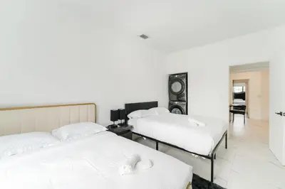 two beds in a room with white sheets at Prime Location 4BR Villa with Pool in Miami