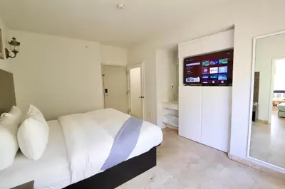 a bedroom with a bed and a tv on the wall at Art Deco 1 Bedroom Apartment Steps to Beach in South of Fifth Neighborhood in Miami Beach
