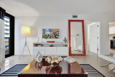 a living room with a mirror and a table at Stunning 2-Bedroom Condo with Beach Service 614 in Miami Beach