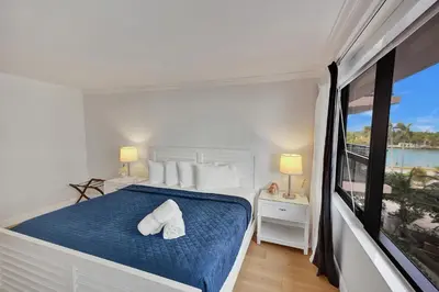 a bedroom with a bed with blue sheets and white pillows at Stunning 2-Bedroom Condo with Beach Service 614 in Miami Beach