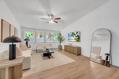 a living room with a ceiling fan and a mirror at POOL & BBQ with the family in Biscayne Park