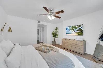 a white bedroom with a bed and a ceiling fan at POOL & BBQ with the family in Biscayne Park