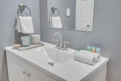 a bathroom with a sink and a mirror and towels at POOL & BBQ with the family in Biscayne Park