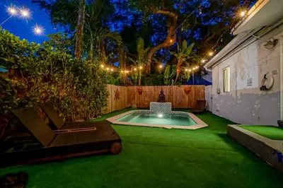 a backyard with a swimming pool and a fence with lights at Buddha House Pool Big Yard in Miami