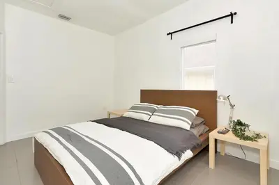 a bedroom with a bed and a table and a window at Wynwood House With Pool, Hotub and Parking in Miami