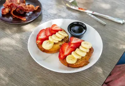 a plate of food with strawberries and bananas on it at North Beach Hotel in Fort Lauderdale