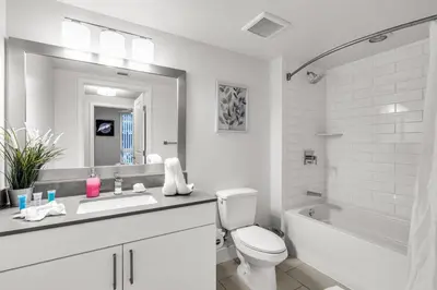 a white bathroom with a toilet and a sink and a tub at Comfort and Convenience 2BR Unit with Free Parking in Miami