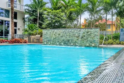 a swimming pool with blue water and palm trees at Comfort and Convenience 2BR Unit with Free Parking in Miami