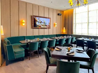 a dining room with tables and green chairs at Stylish One Bedroom in the heart of vibrant Downtown- Daily resort fee and parking not included in Miami